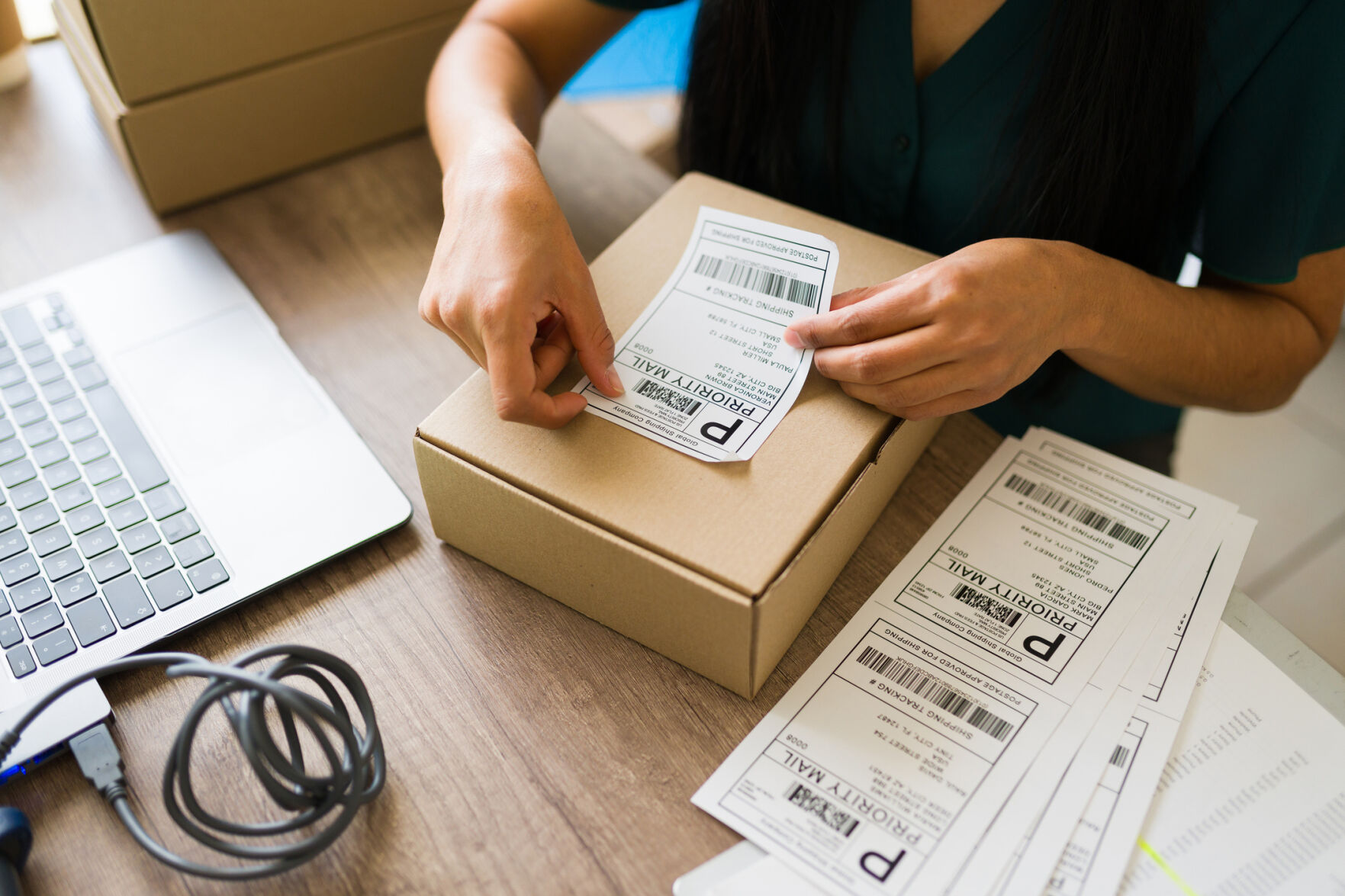 stock image of a woman preparing a package for shipping in her small business office